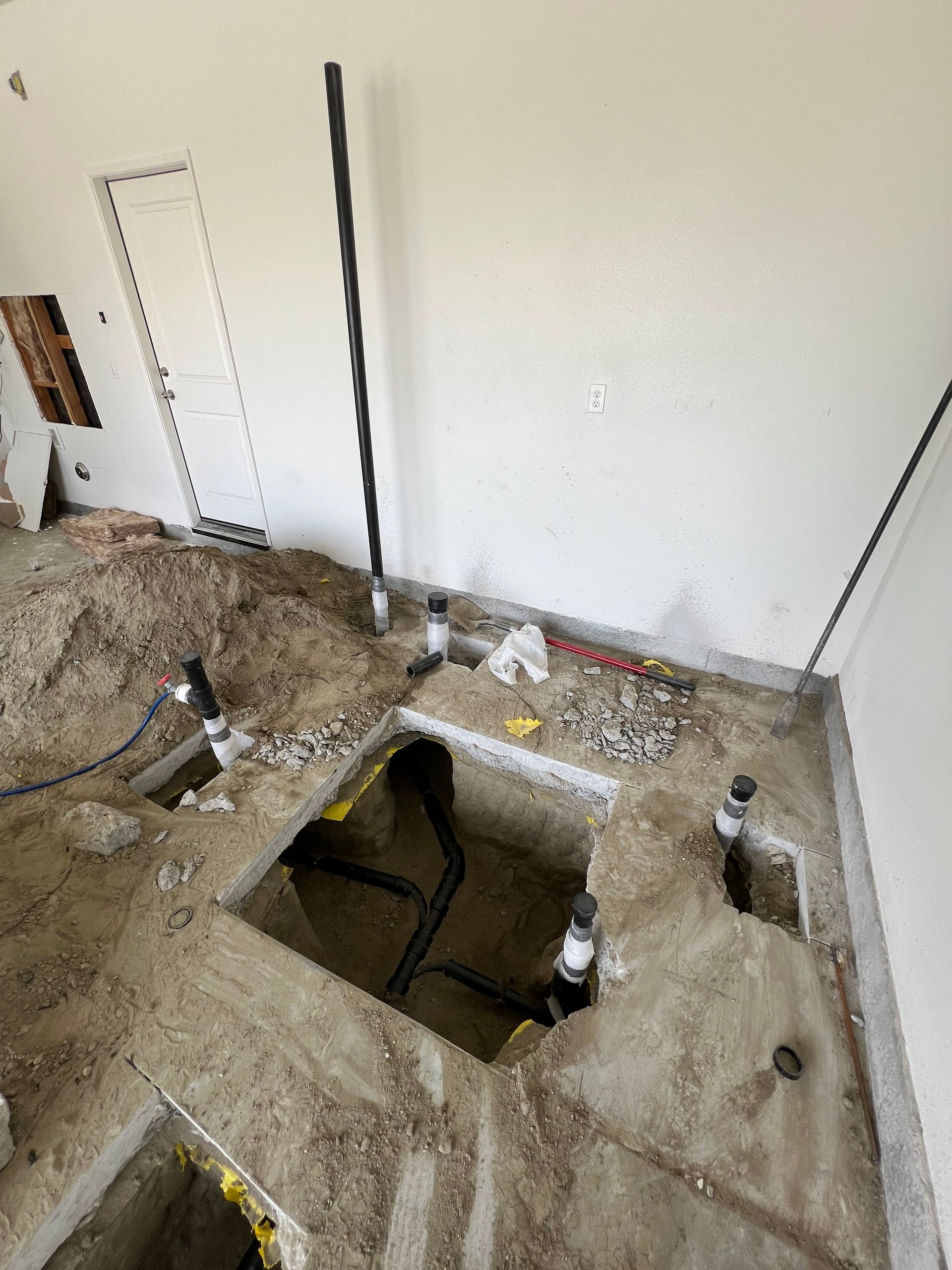 A room with a hole in the floor and a hose coming out of it.