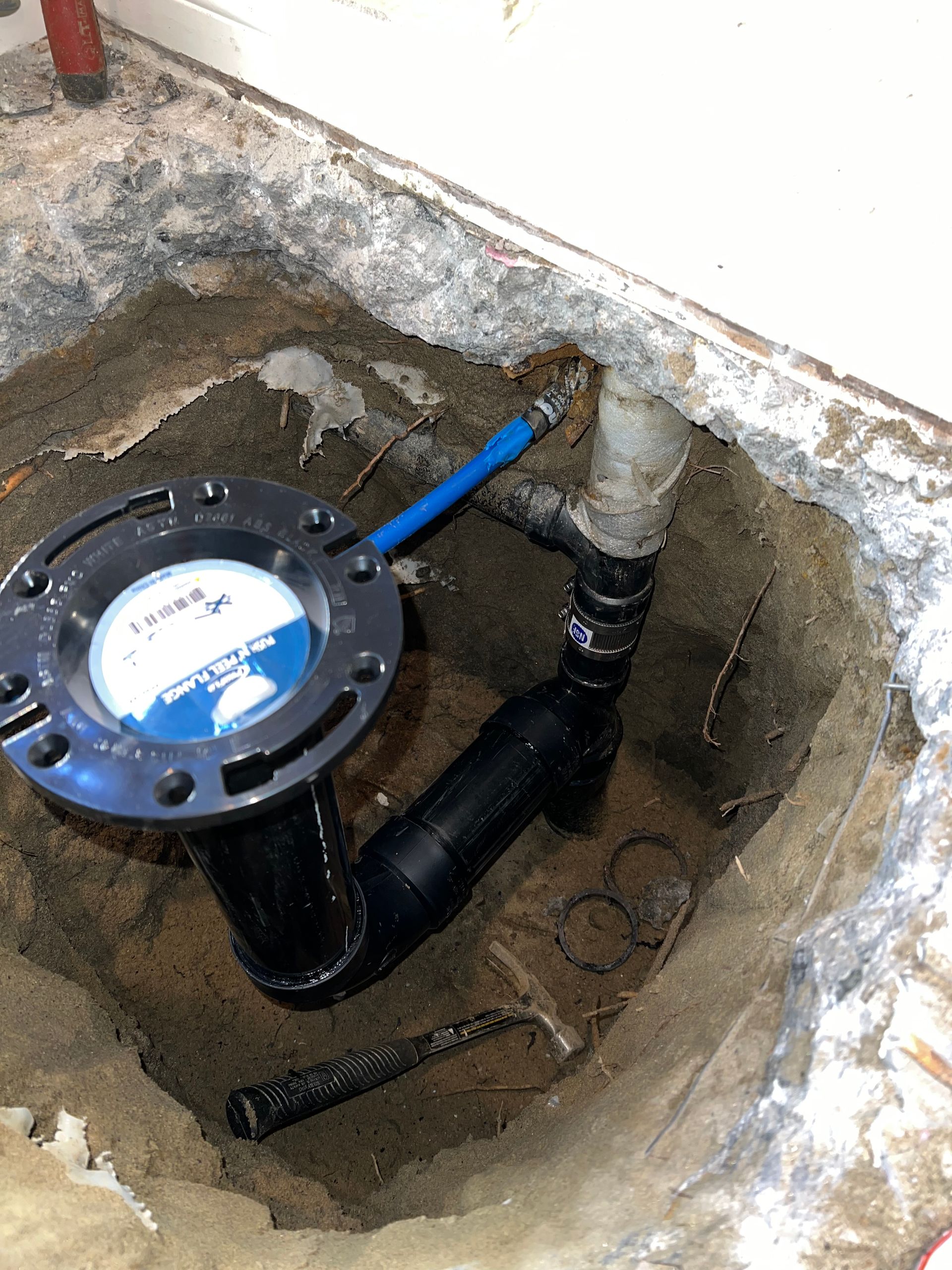A drain pipe is being installed in a hole in the ground.