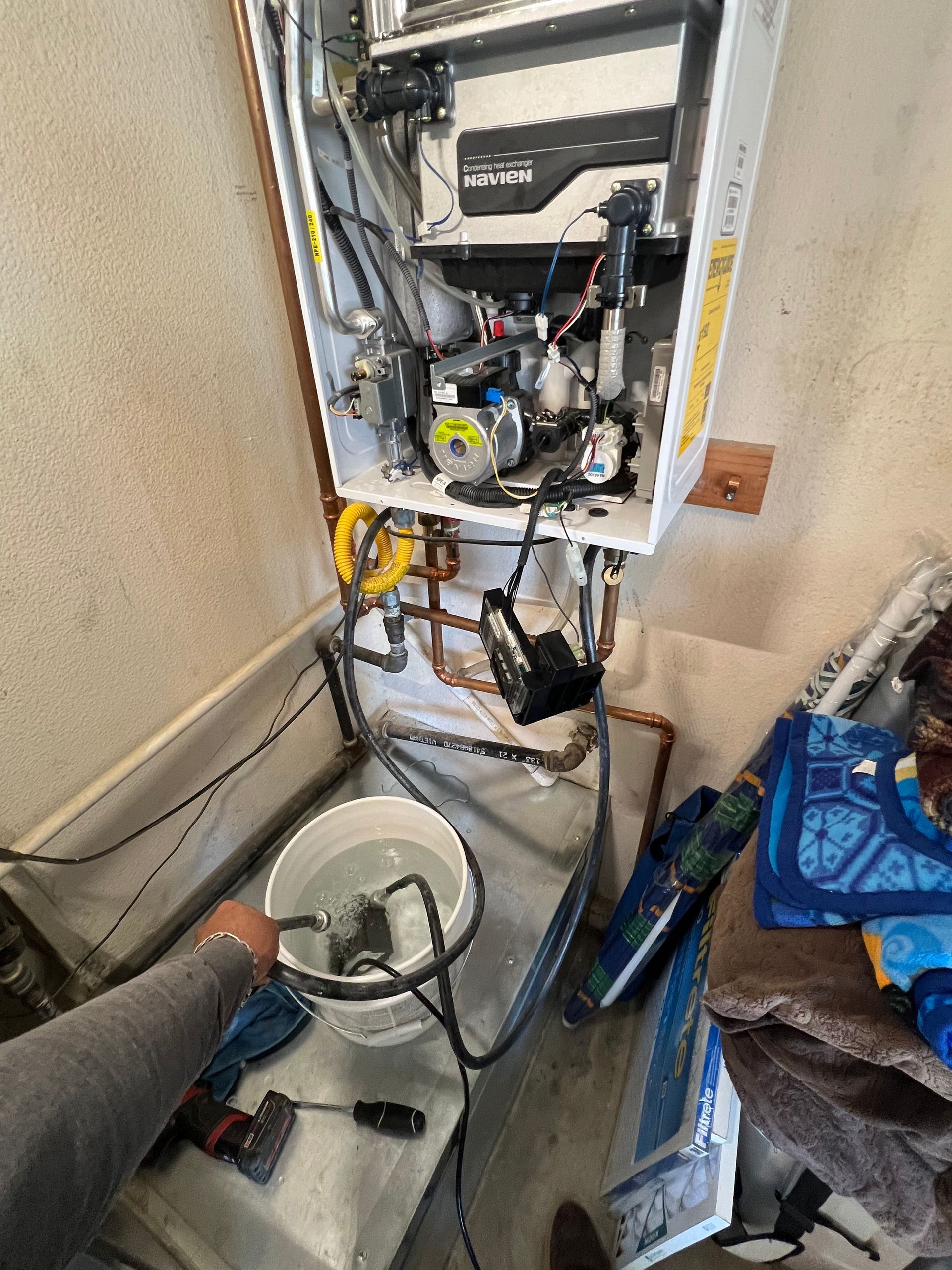 A person is working on a boiler in a room.