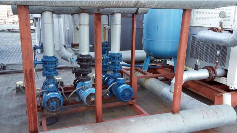 Un montón de tuberías y bombas se encuentran encima de una estructura de madera.