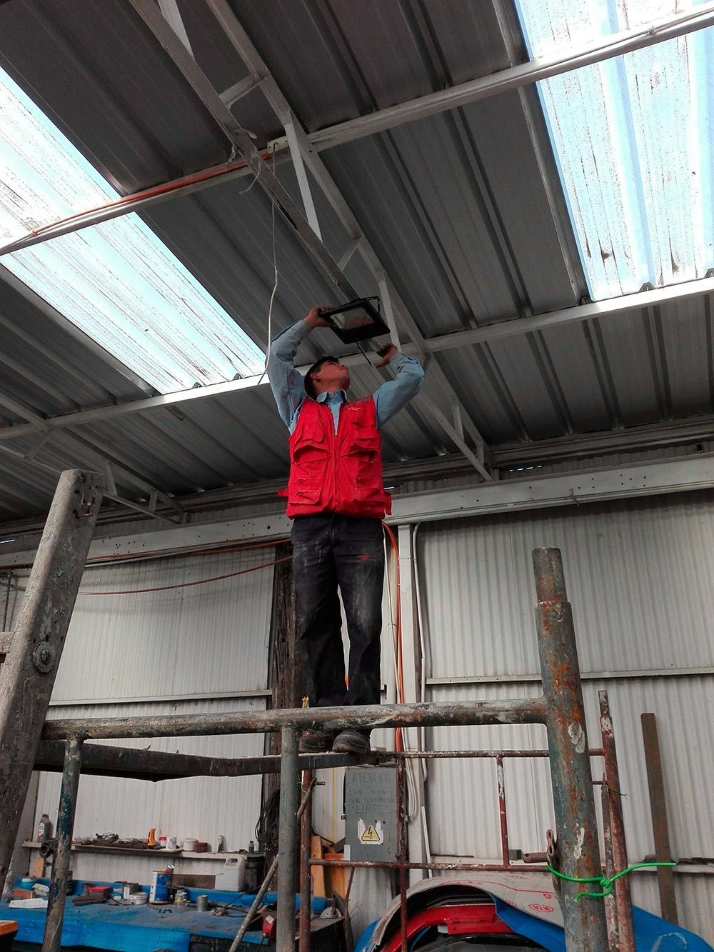 Un hombre está de pie sobre un andamio en un edificio.