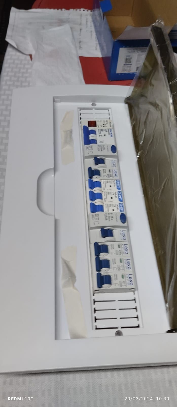 Una caja blanca llena de equipos eléctricos está sobre una mesa.