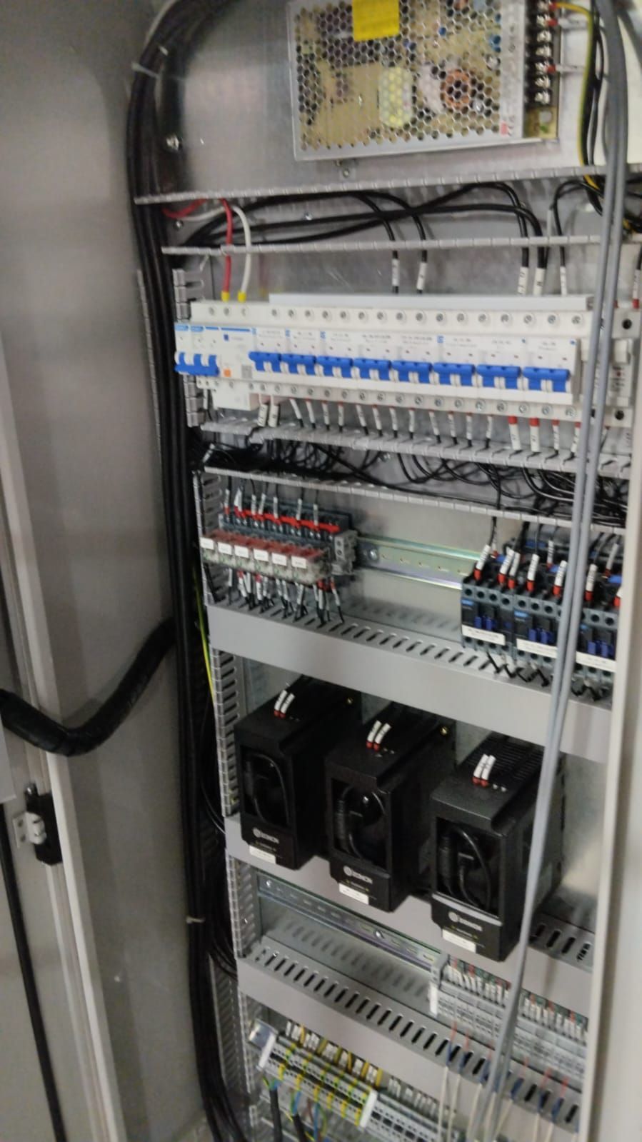 El interior de un armario eléctrico con muchos cables y componentes eléctricos.