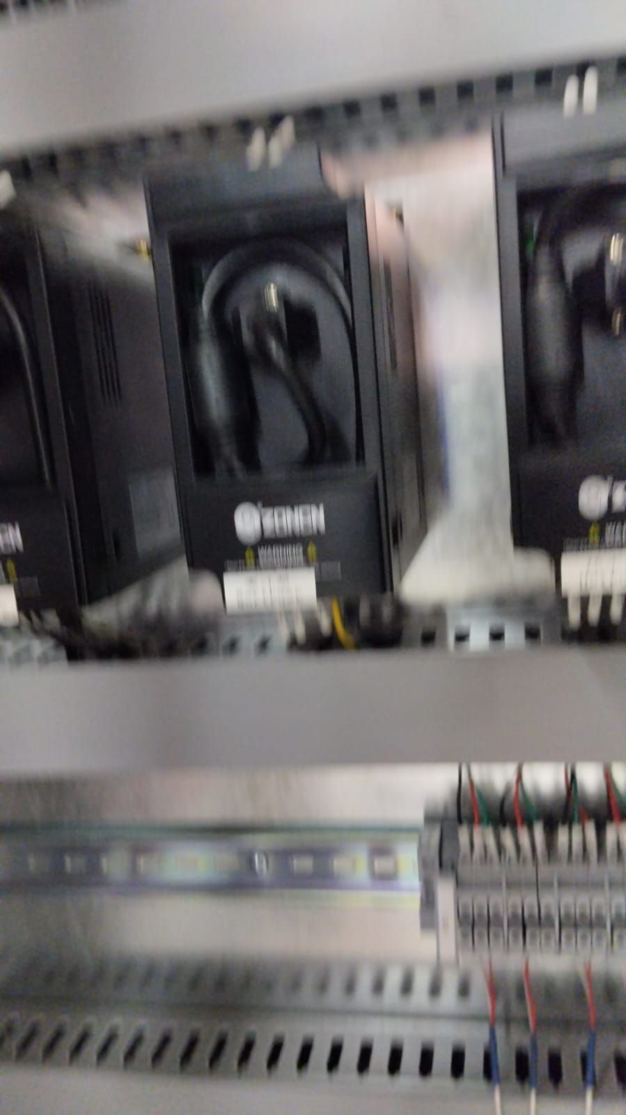 Un primer plano de un panel de control con un montón de equipos eléctricos en su interior.