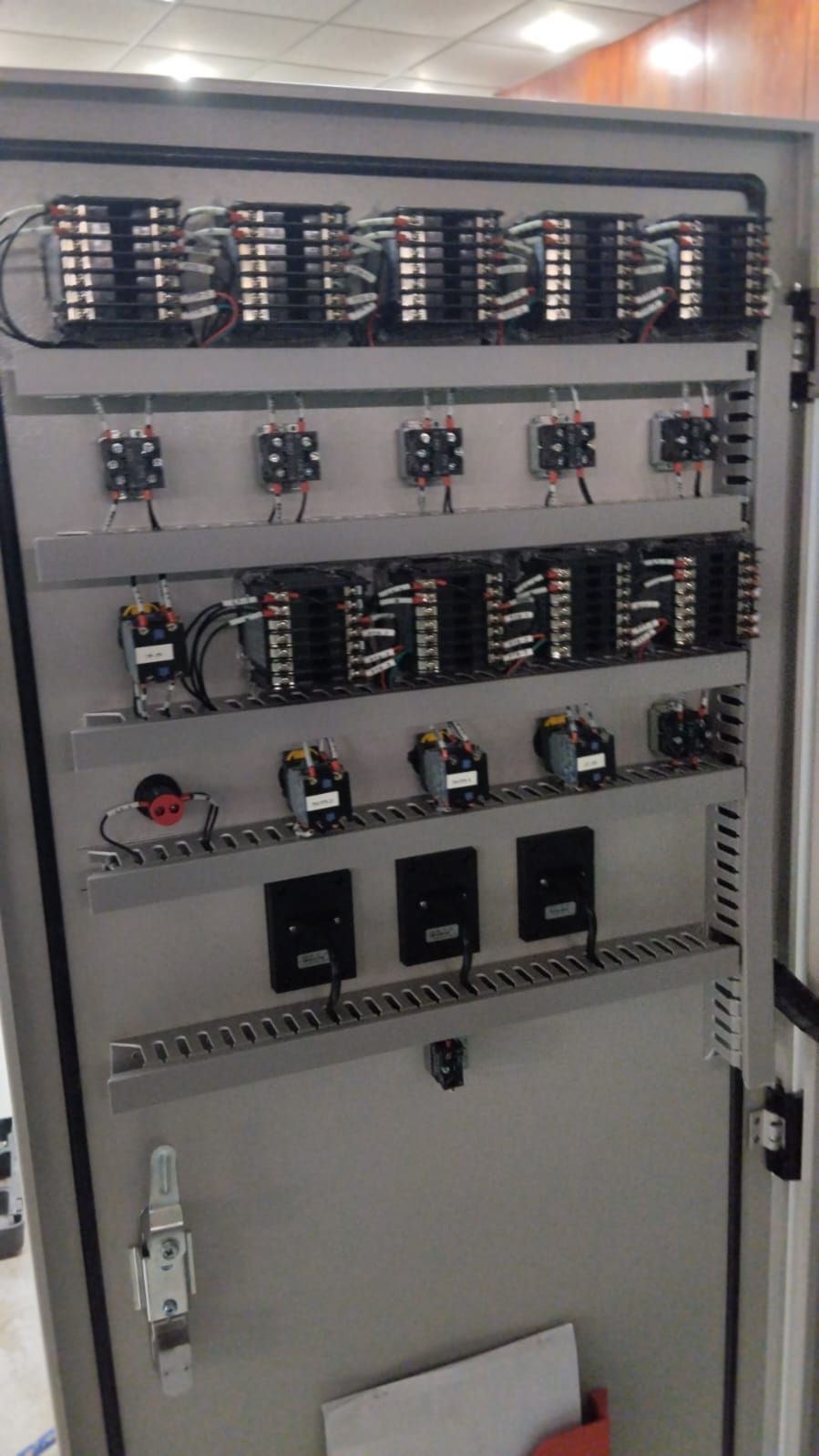 Un panel eléctrico grande con muchos cables colgando de él.