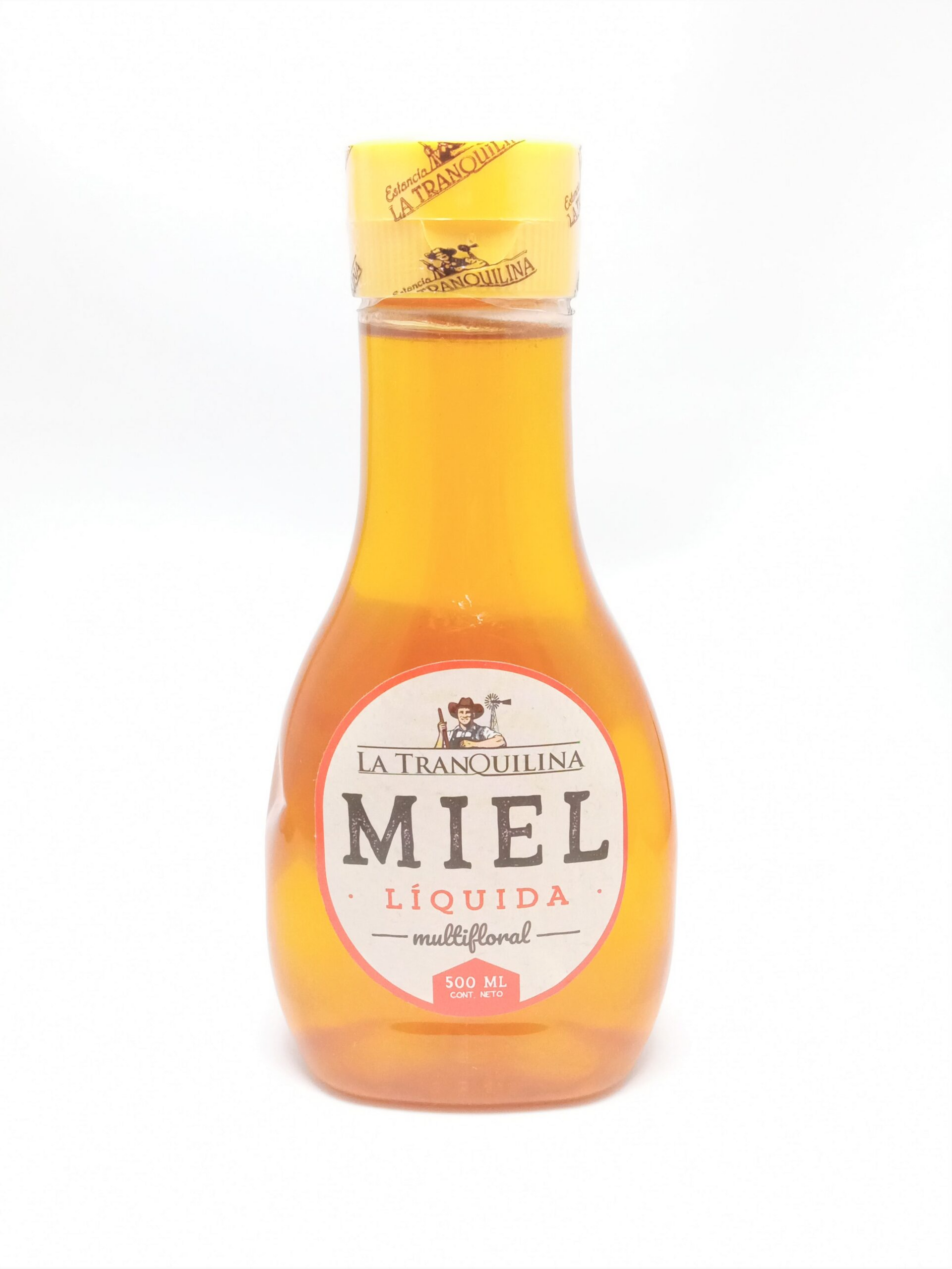 Una botella de miel líquida sobre un fondo blanco.