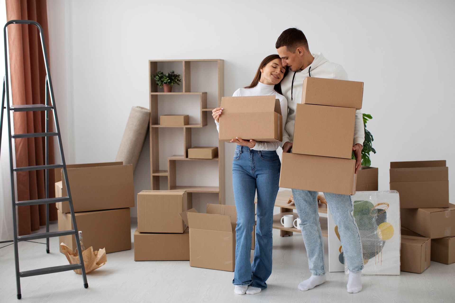 a man and woman holding cardboard boxes in a room