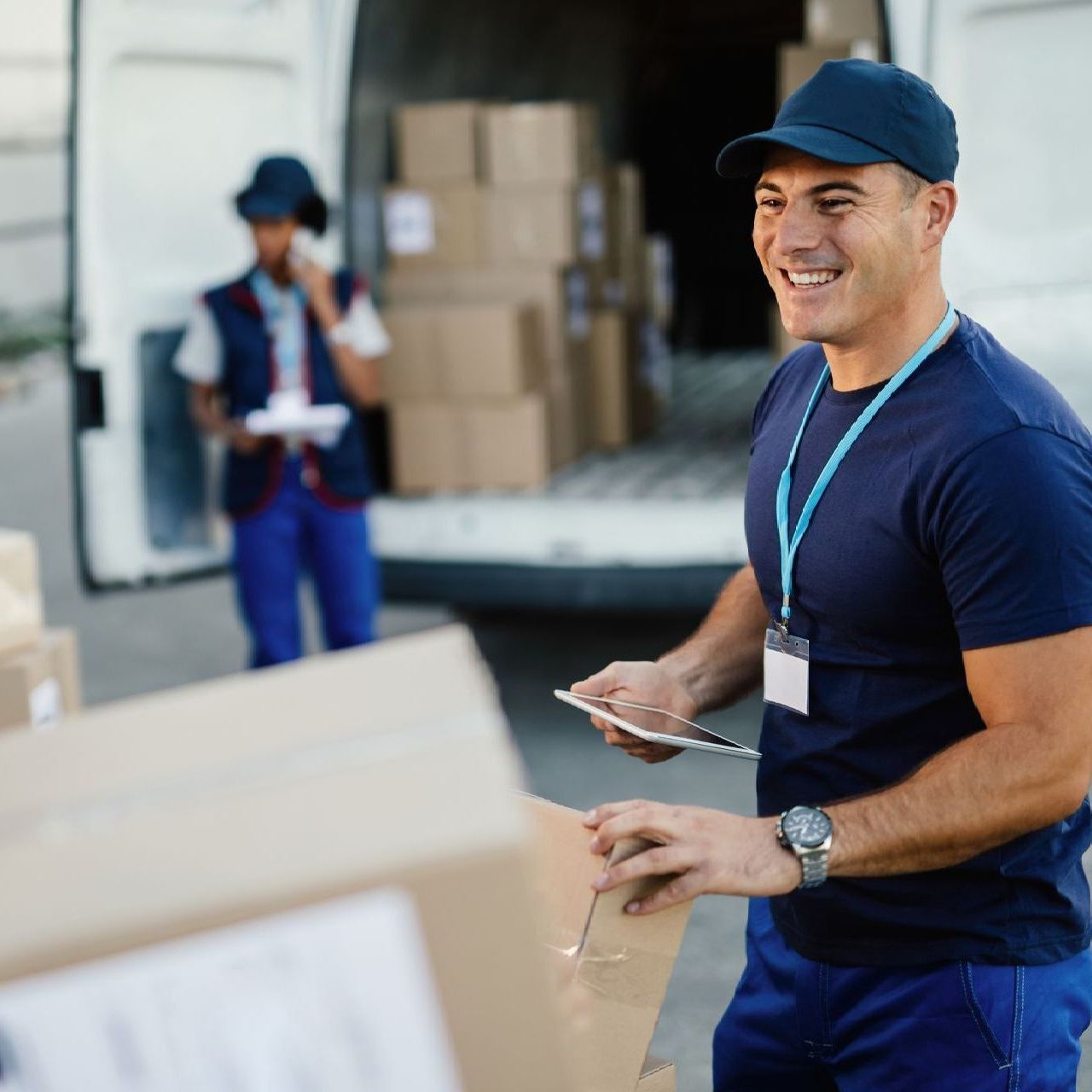 a man in a blue shirt is smiling while holding a box