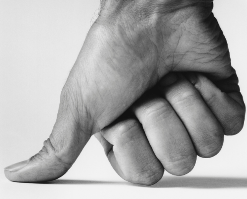 A black and white photo of a hand pointing down