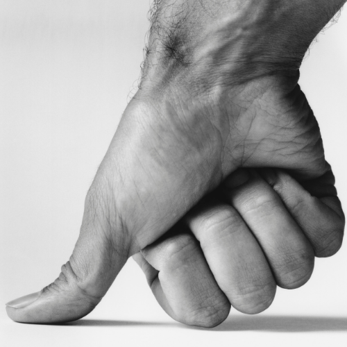 A black and white photo of a hand pointing down