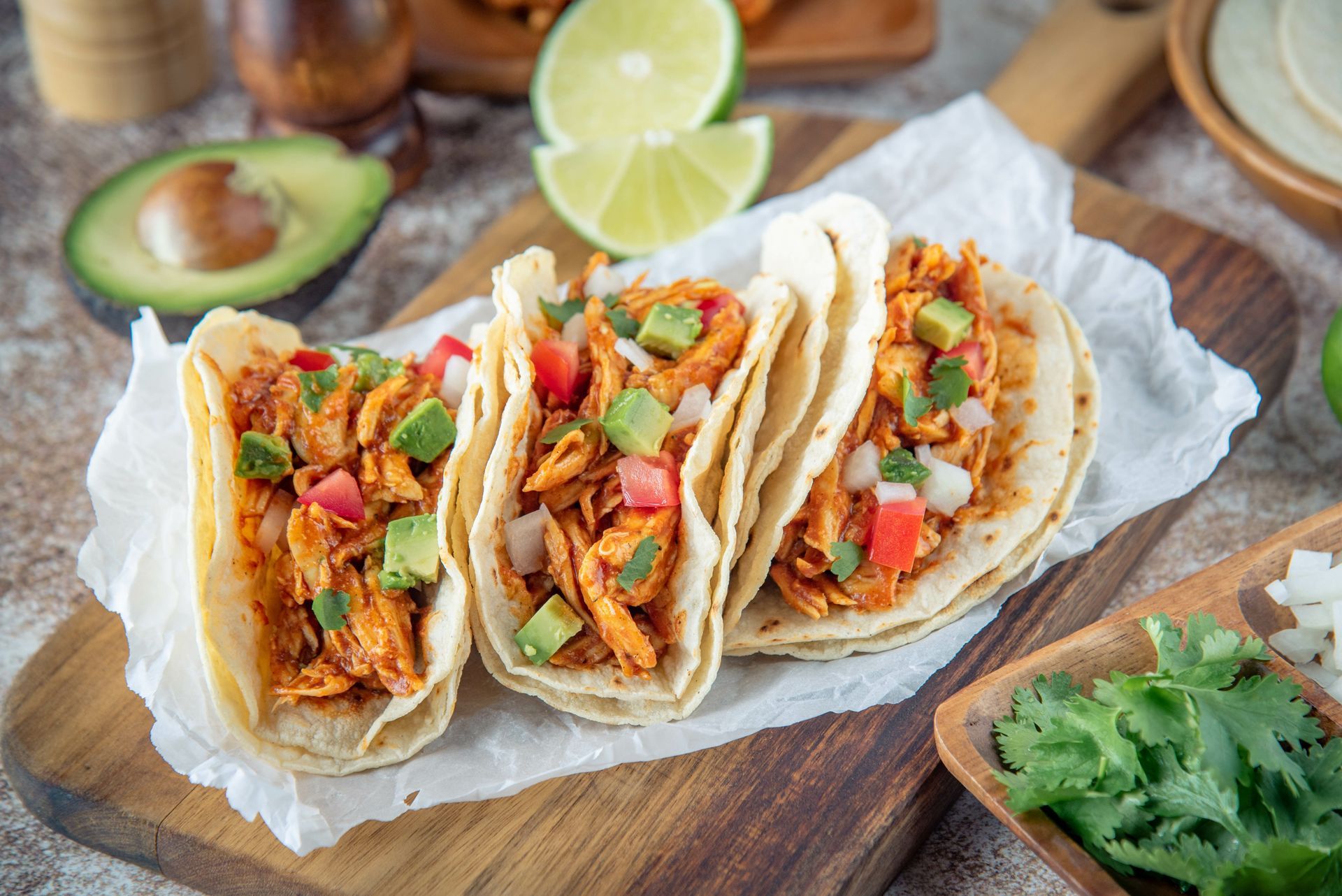 A wooden cutting board topped with chicken tacos.
