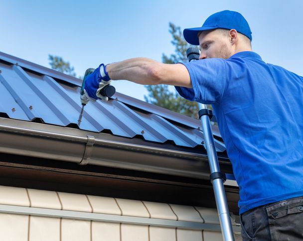 Metal roofing - roofer working on the house roof