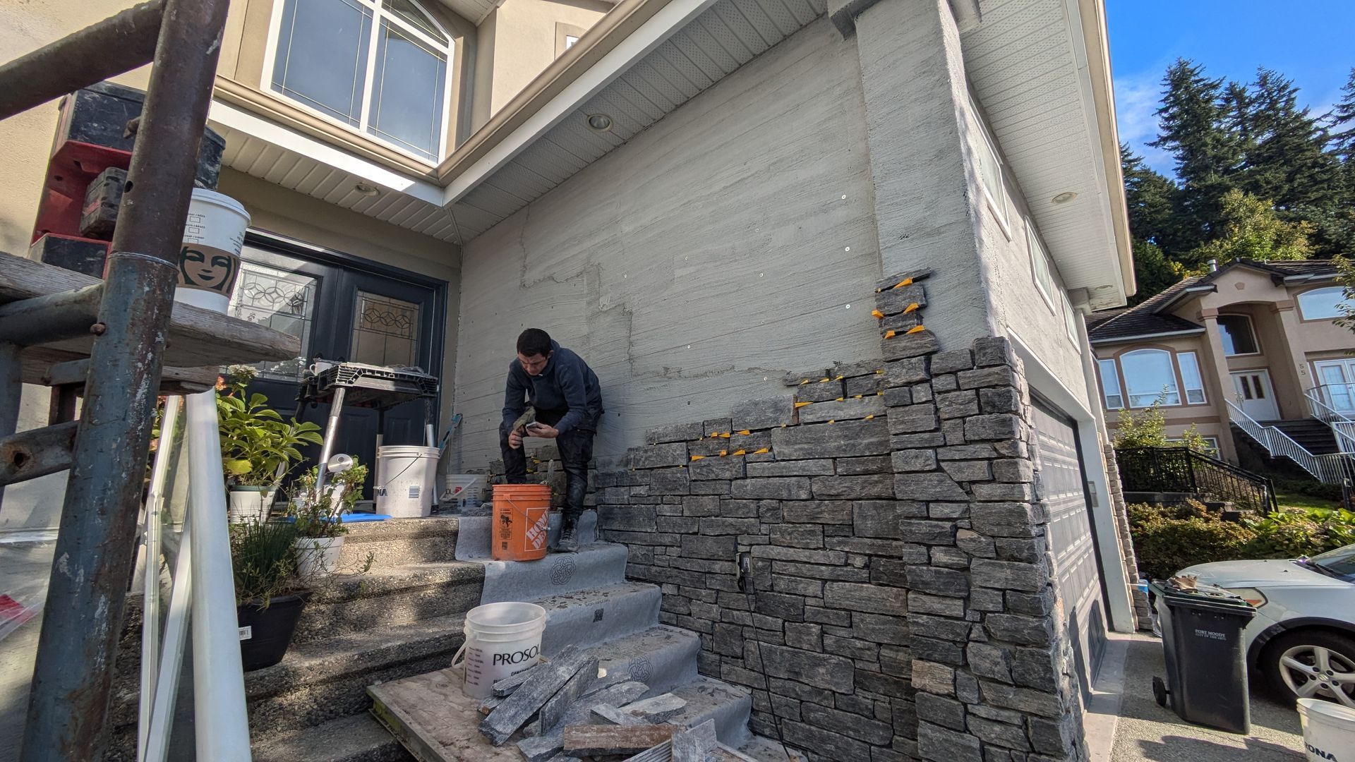 A stone mason working on natural stone siding installation