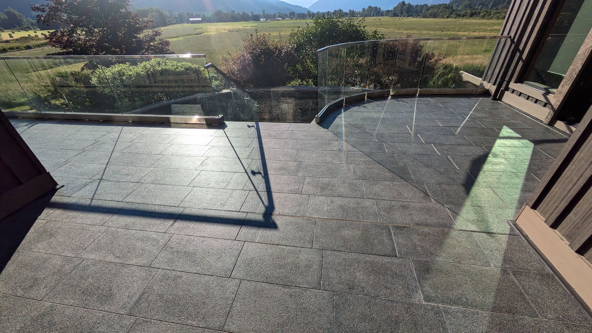 Get quality gray granite tiles just like these installed at your home or business! Gray granite tile flooring on an outdoor patio facing a mountains in the distance