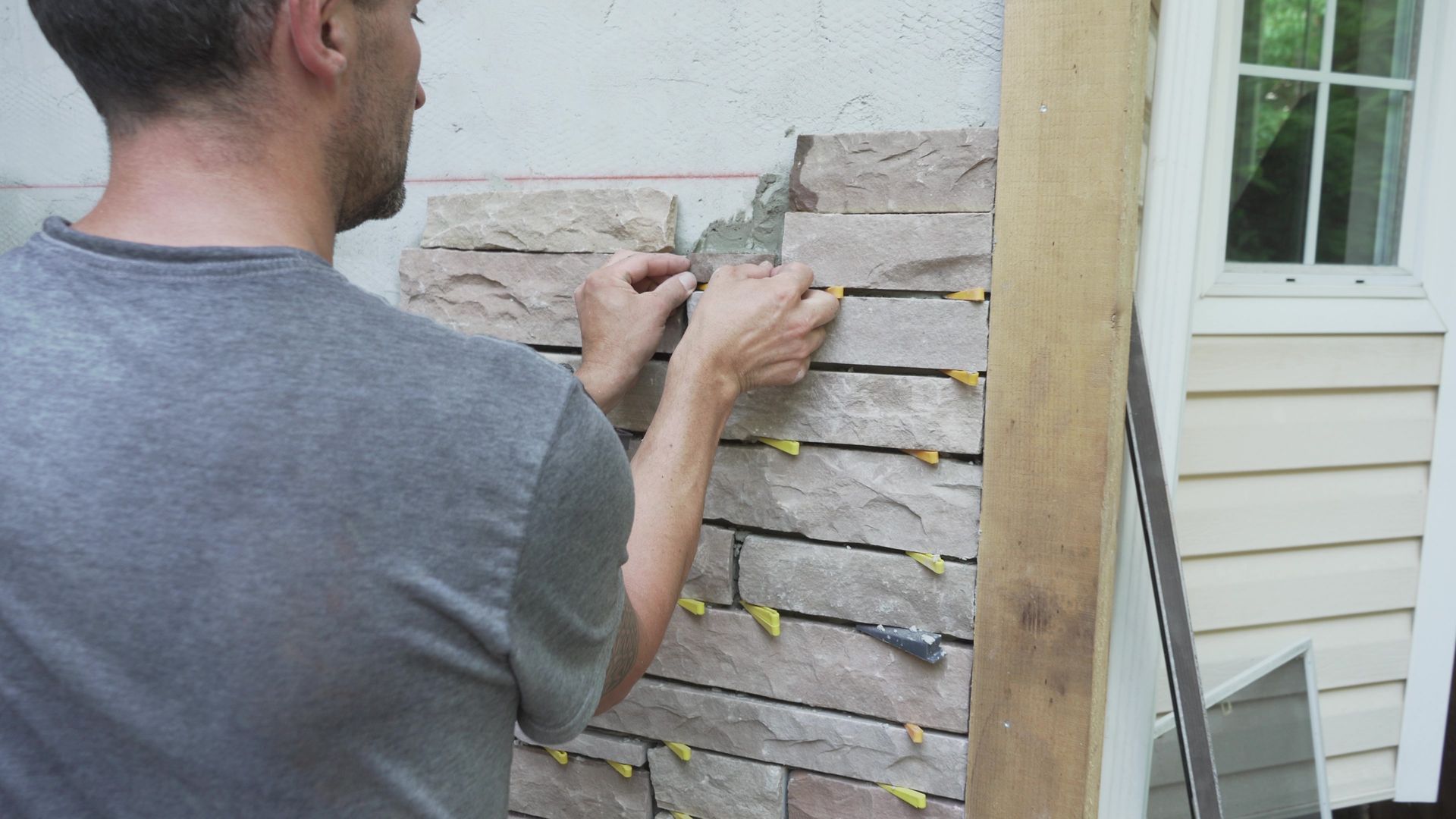 Chris from Bricked Masonry is installing natural stone siding om the exterior of a residential home in Vancouver BC.