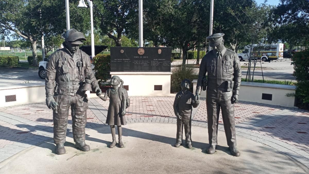 A statue of two men and two children standing next to each other