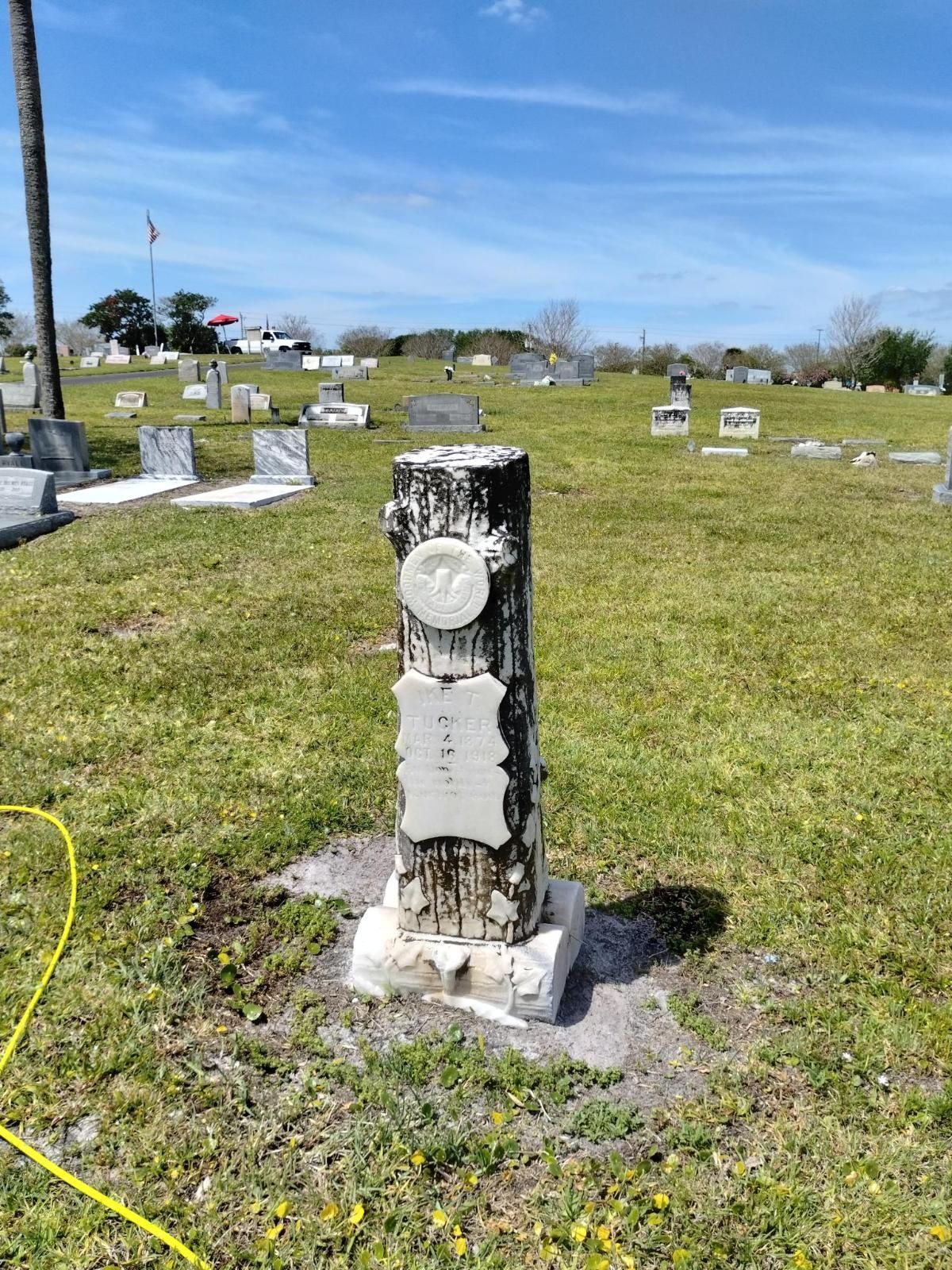 A gravestone in a cemetery with a clock on it.