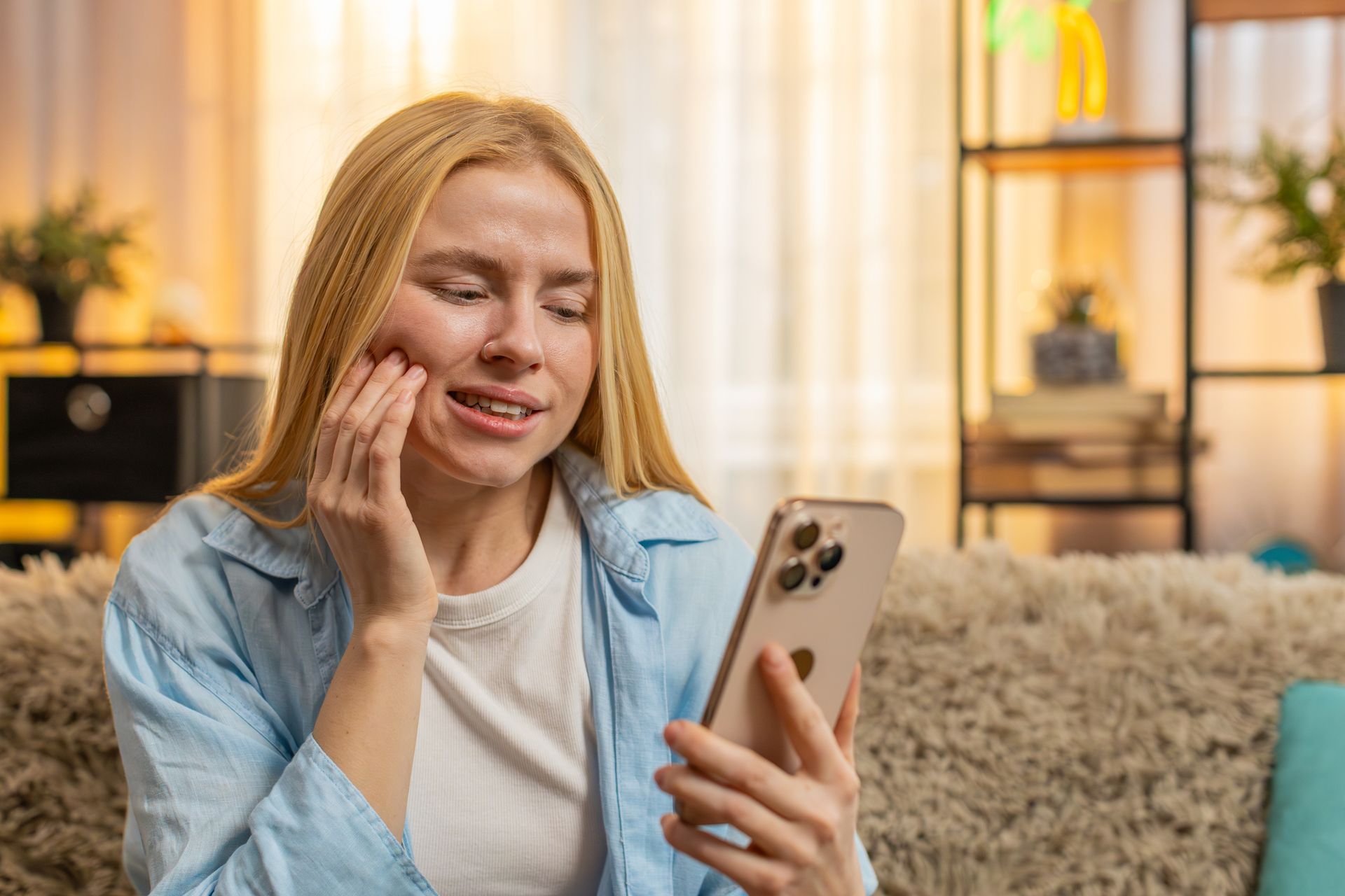 A woman touching her cheek due to tooth pain. A woman touching her cheek due to tooth pain.