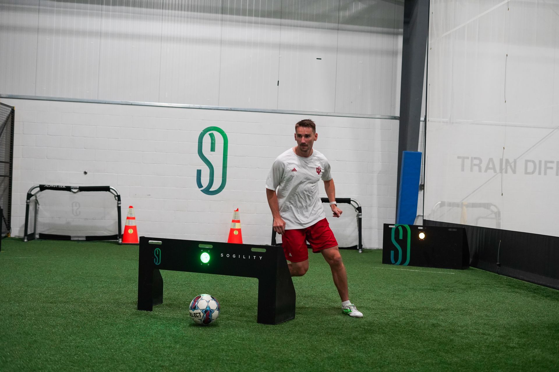 A man is kicking a soccer ball on a field.