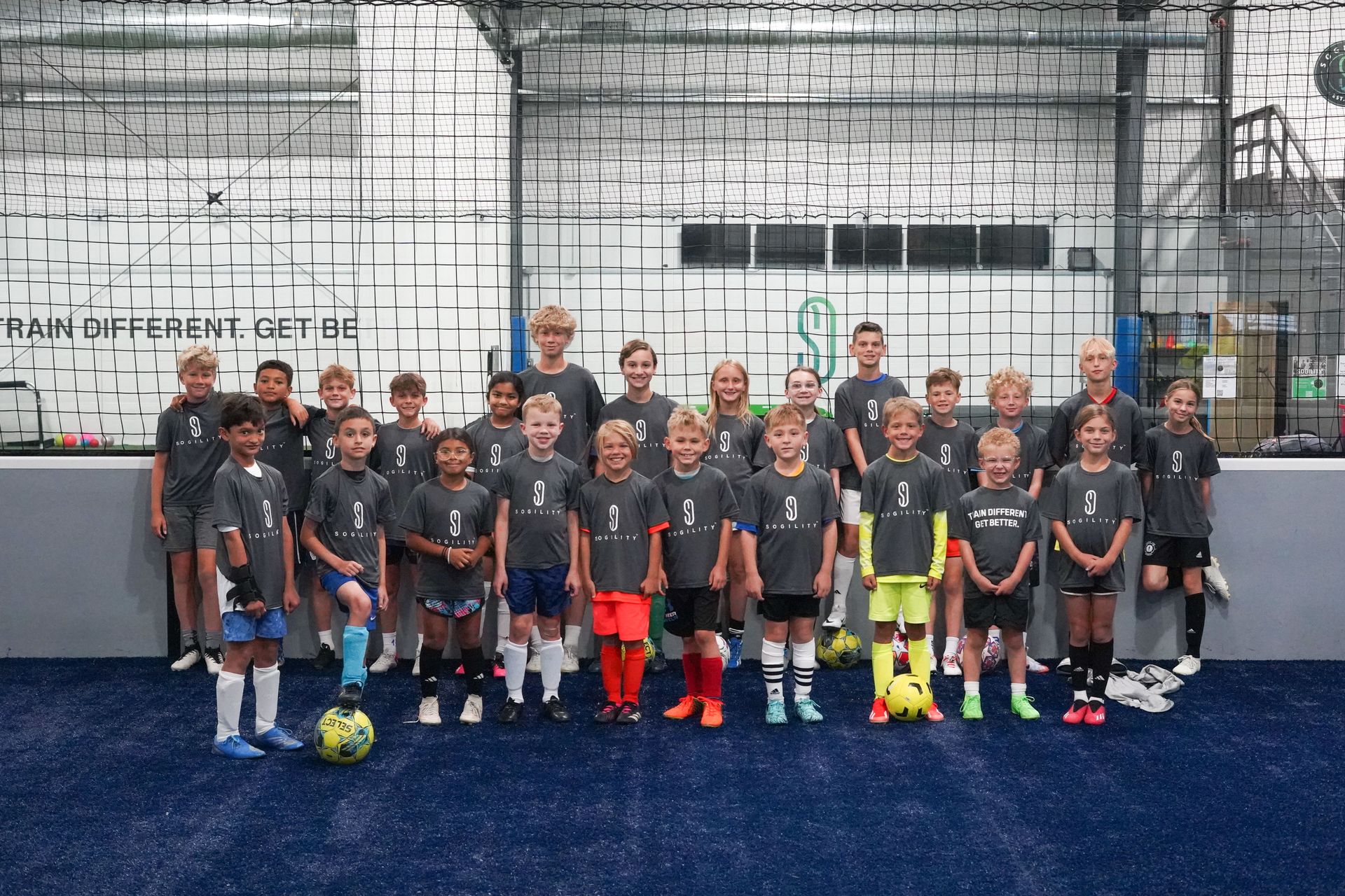 A group of children are posing for a picture on a soccer field.