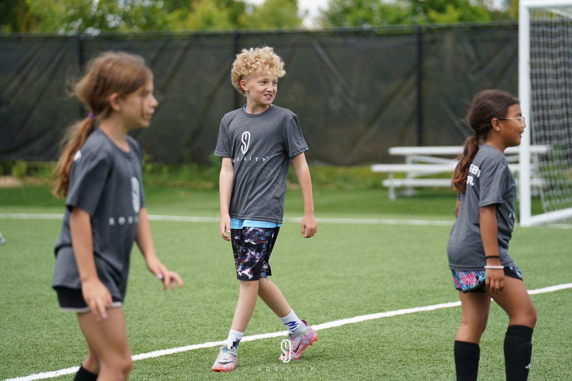 A group of young children are playing soccer on a field.