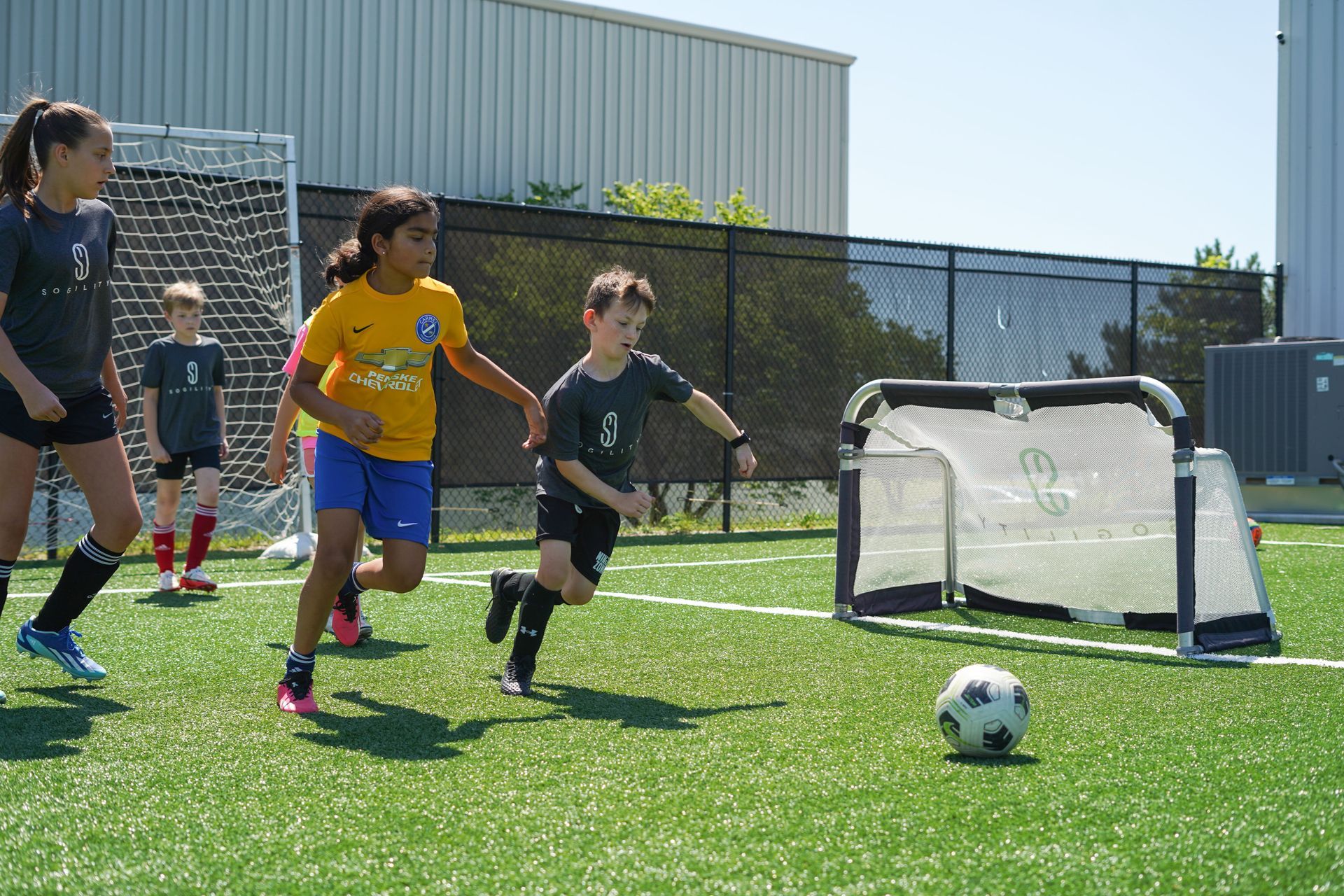 A group of children are playing soccer on a field.