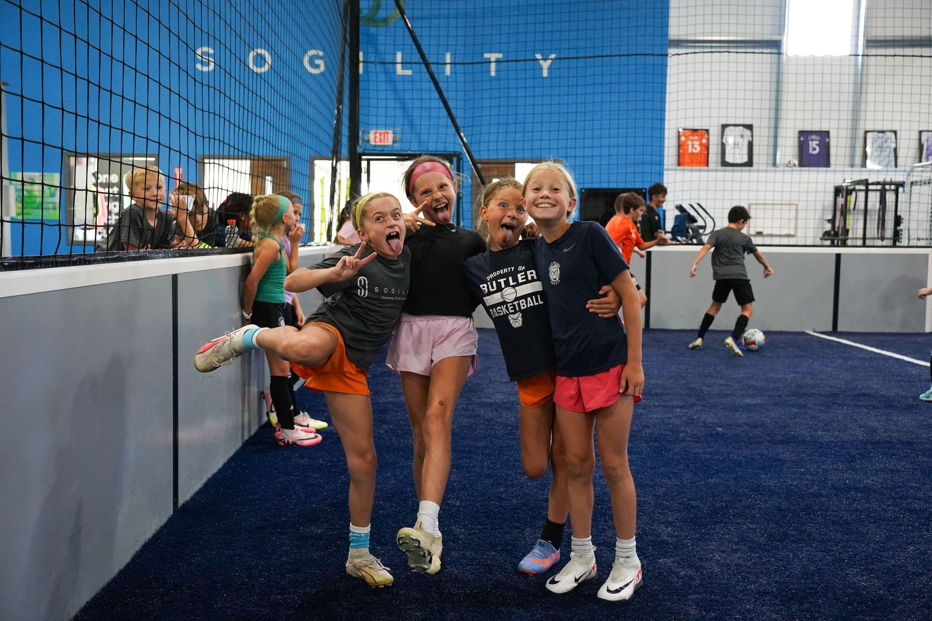 A group of young girls are posing for a picture in a gym.