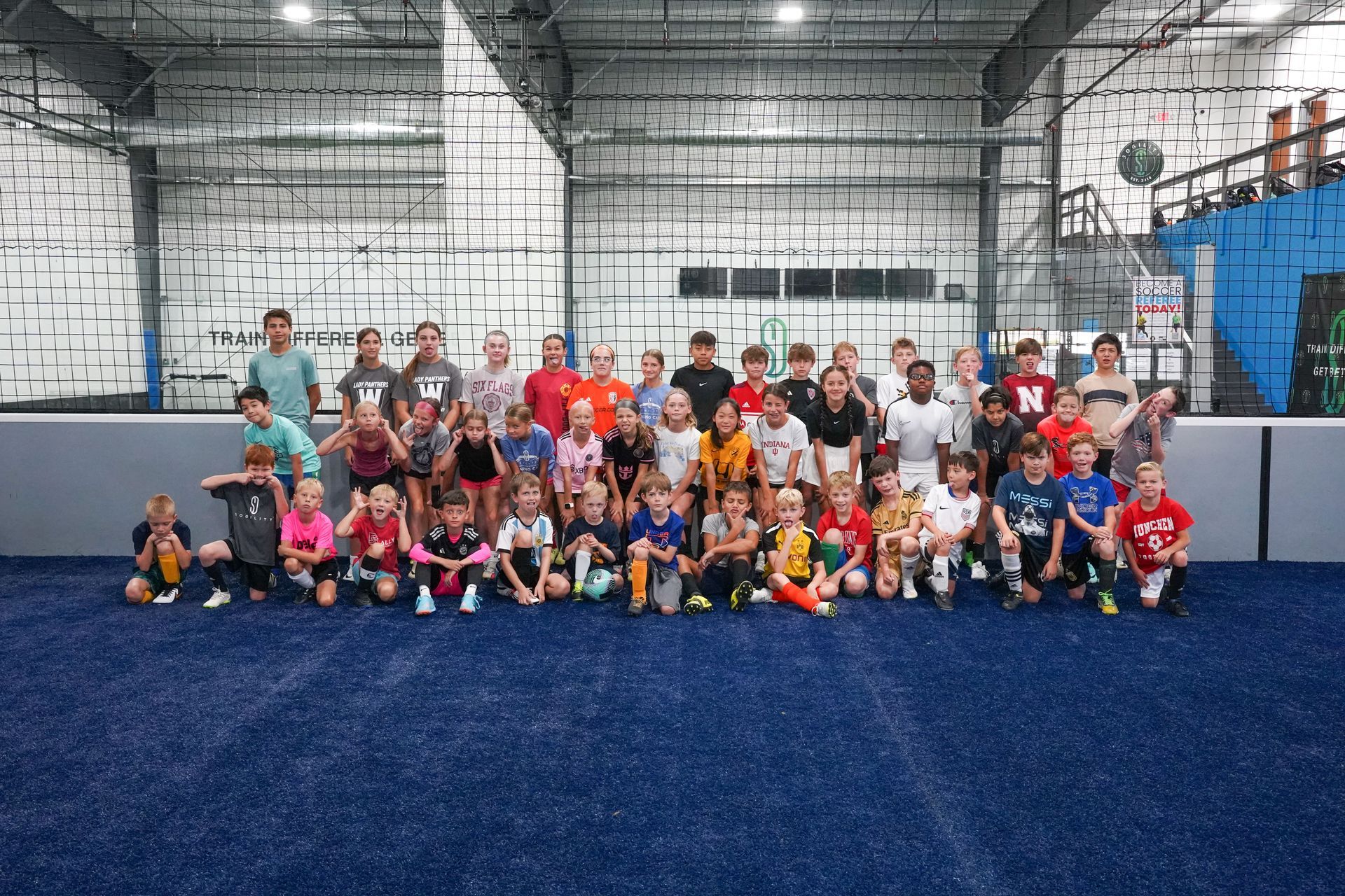 A group of children are posing for a picture in a gym.