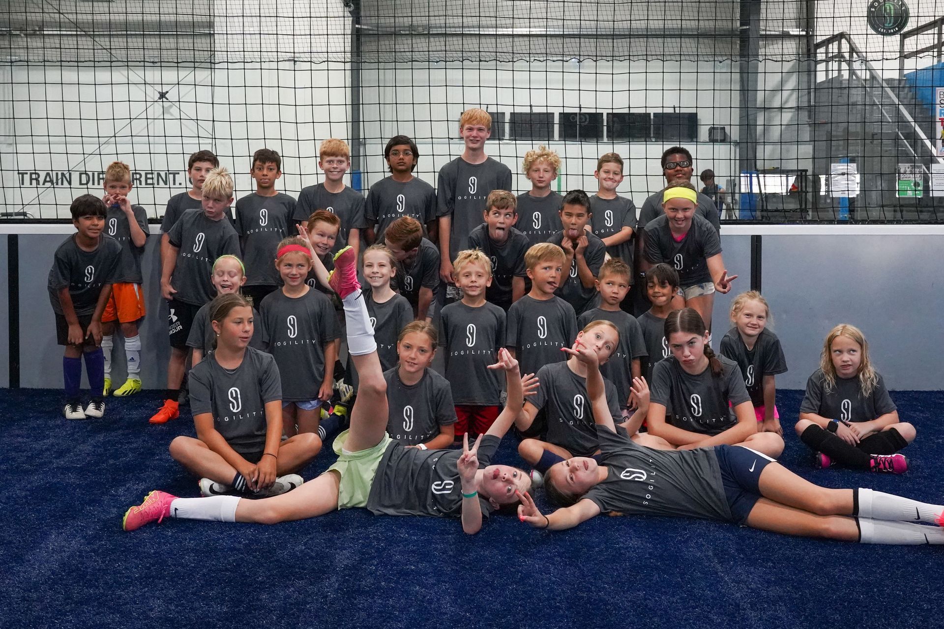 A group of children are posing for a picture in a gym.