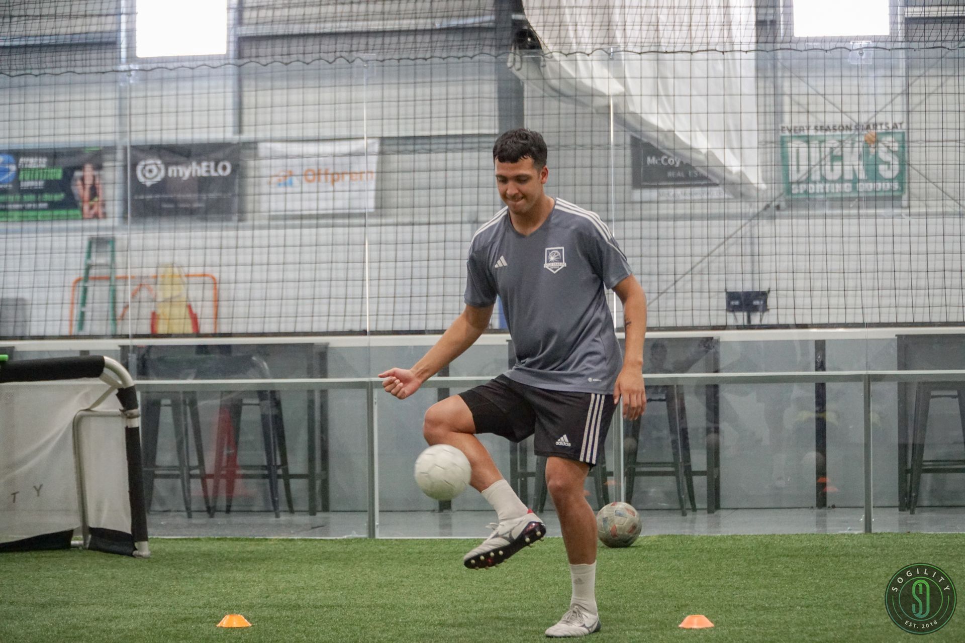 A man is kicking a soccer ball on a field.