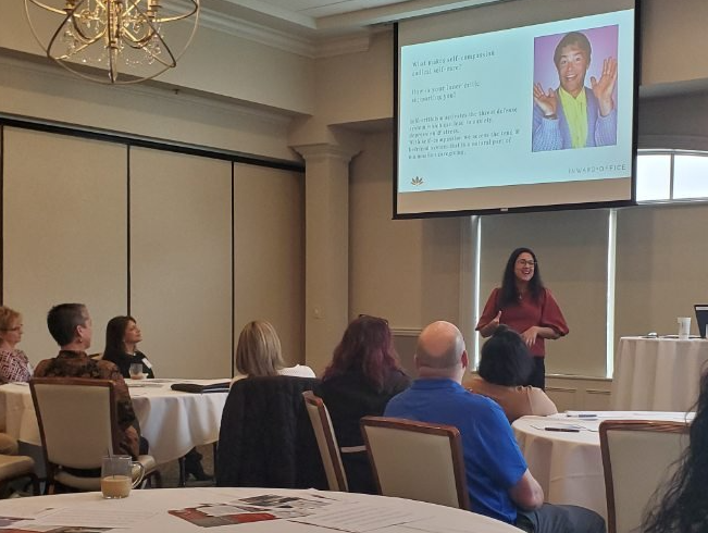 A woman is giving a presentation to a group of people in a conference room.