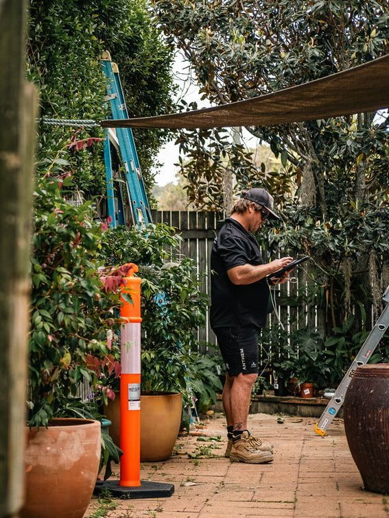 Two Men in Protective Suits Are Working on A Roof of A House — Asbestos Risk Removal In Rockhampton, QLD