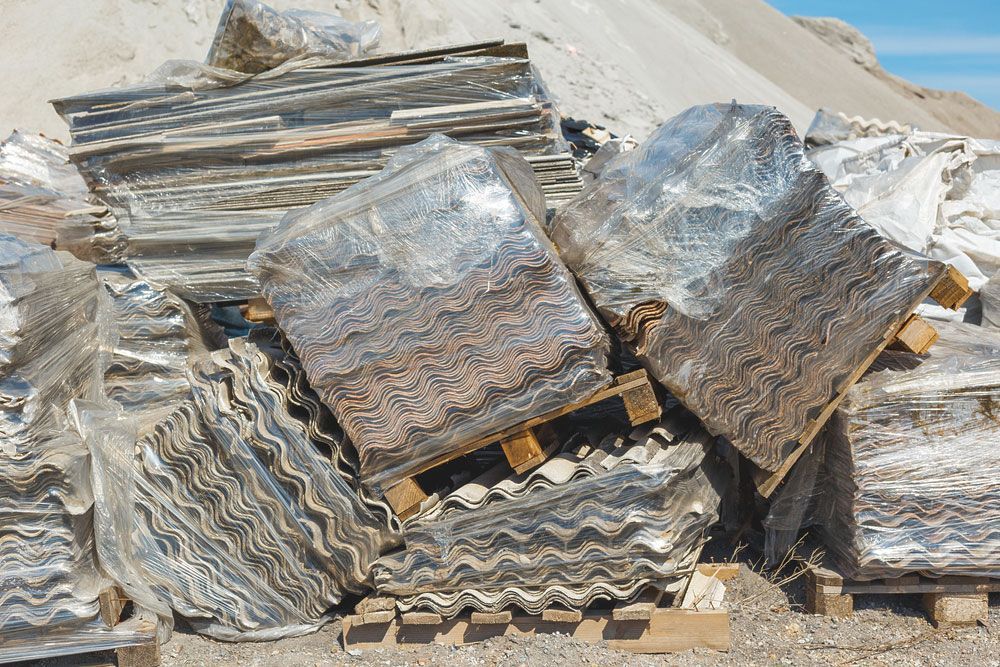 A Pile of Rocks Stacked on Top of Each Other on Wooden Pallets — Asbestos Risk Removal In Gladstone, QLD