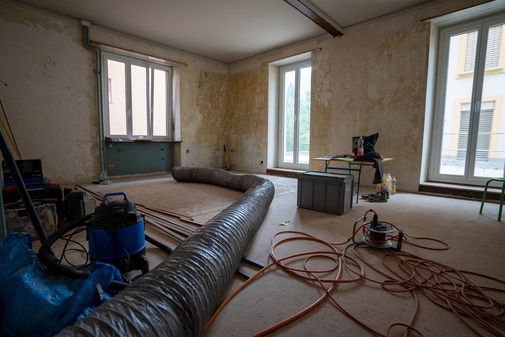 An Empty Room with A Vacuum Cleaner and A Hose on The Floor — Asbestos Risk Removal In Capricorn Coast, QLD