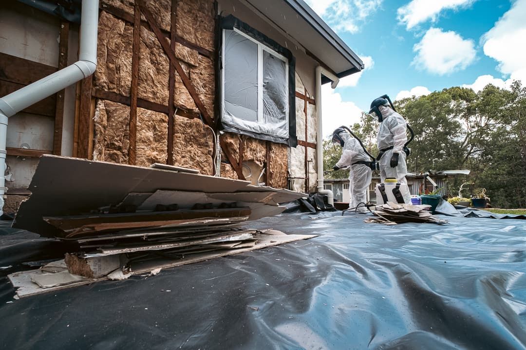 A Person in A Protective Suit Is Holding a Caution Lead Hazard Tape — Asbestos Risk Removal In Rockhampton, QLD