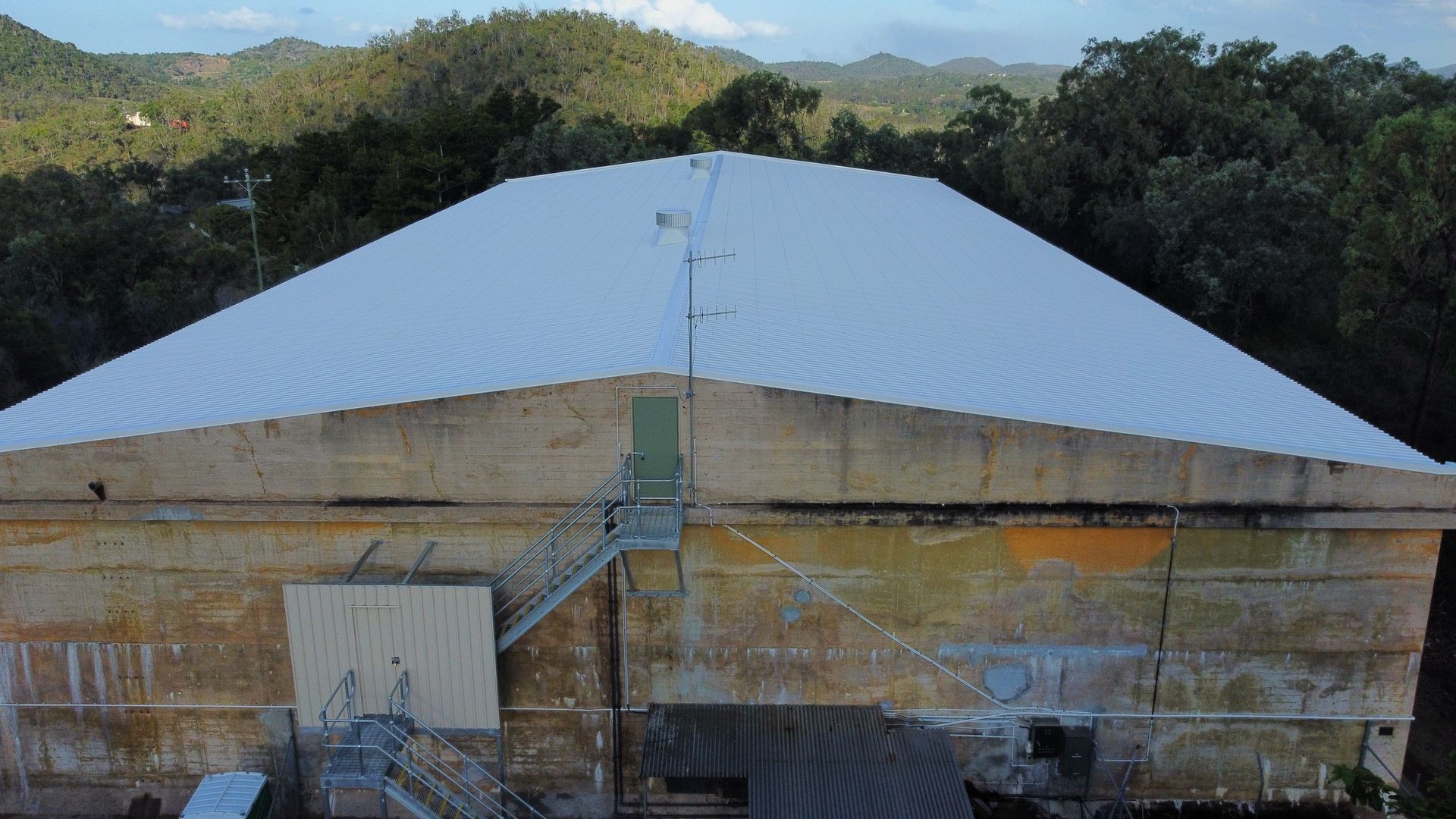 Two Men in Protective Suits Are Working on The Side of A House — Asbestos Risk Removal In Capricorn Coast, QLD