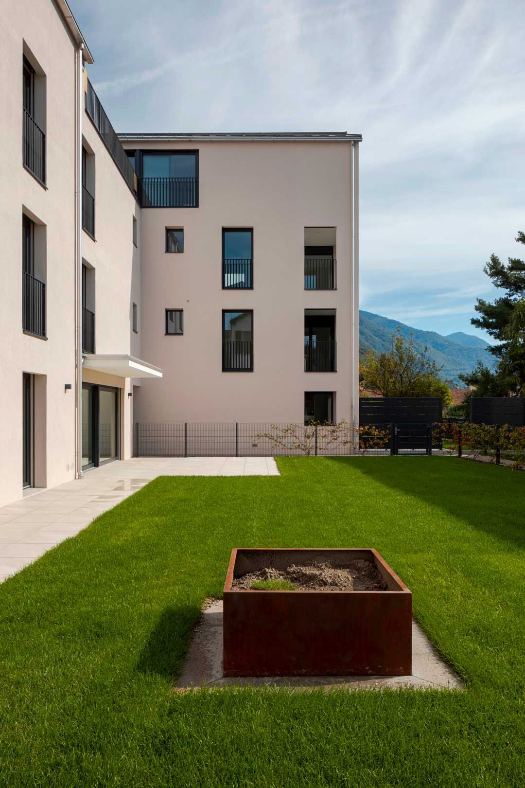 Un grande edificio bianco con un rigoglioso prato verde davanti.