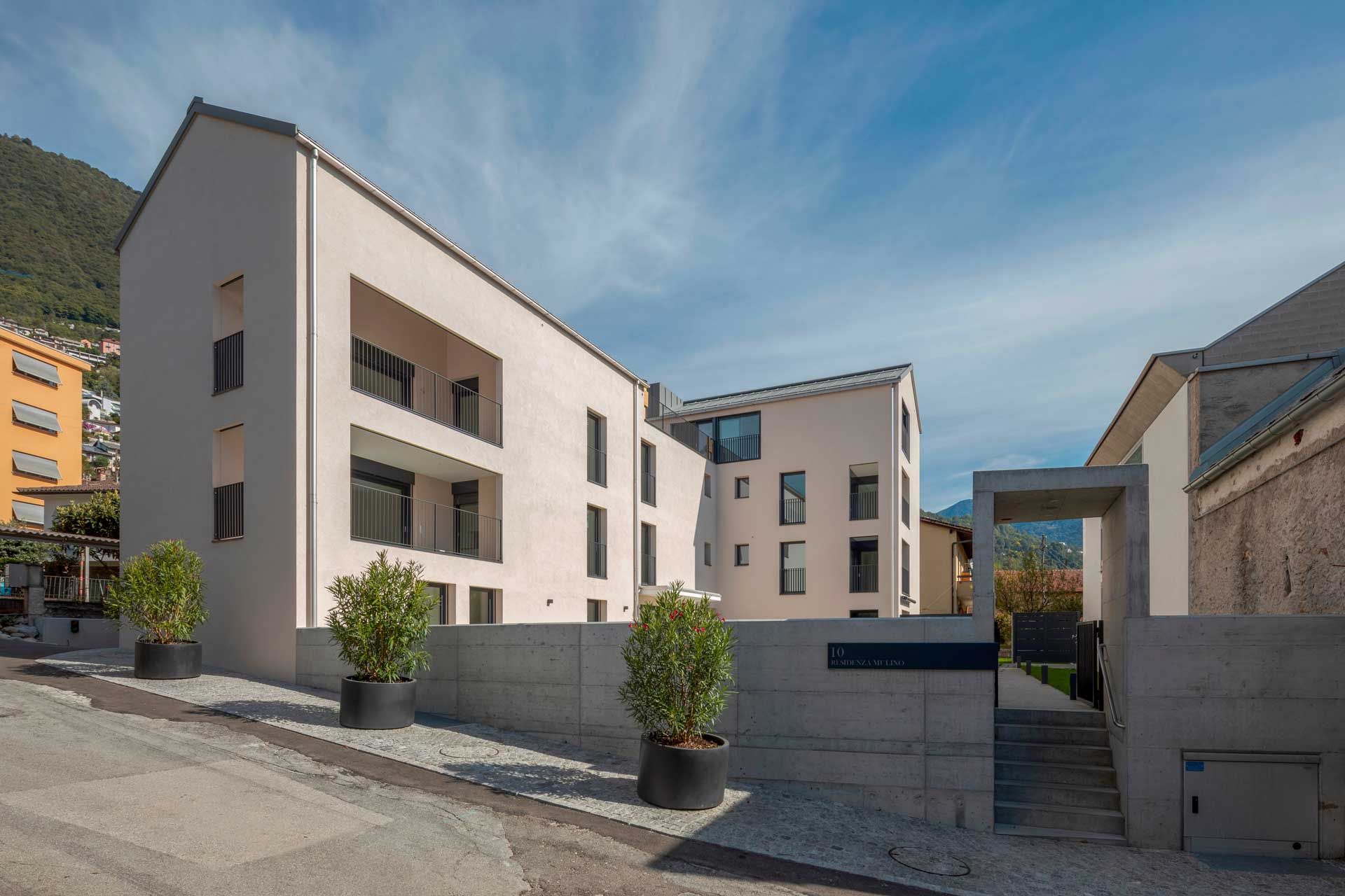 Un edificio con molte finestre e qualche pianta in vaso davanti