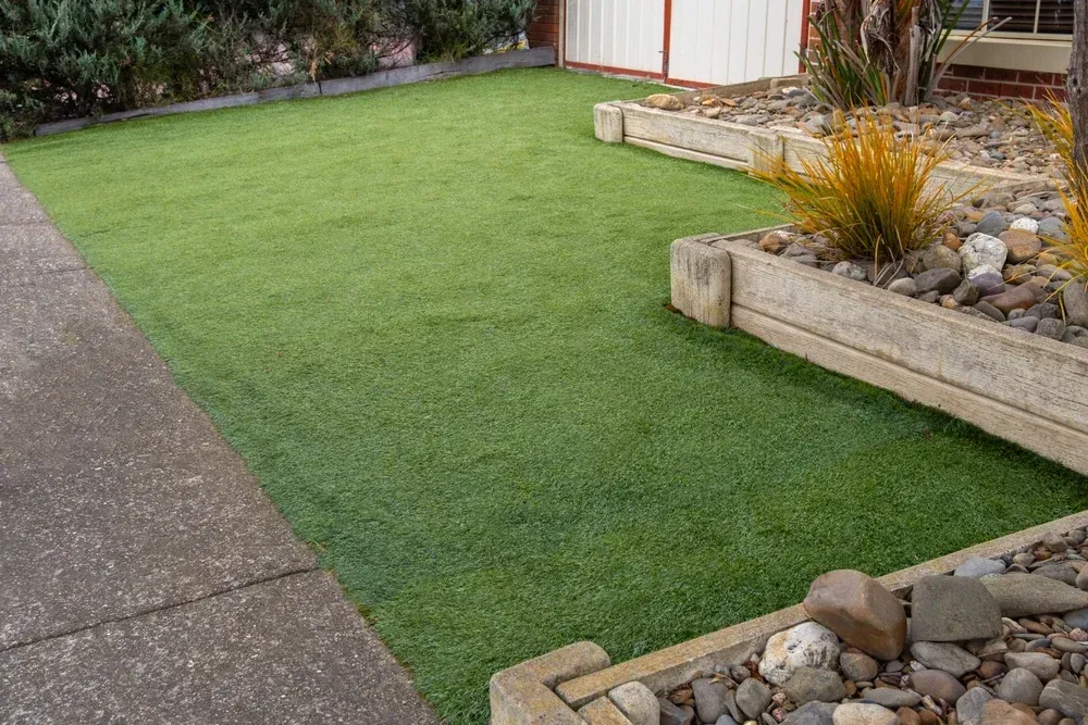 Green lawn beside a paved walkway and rock garden in a residential yard — Coastline Earthworks in Helensvale, QLD