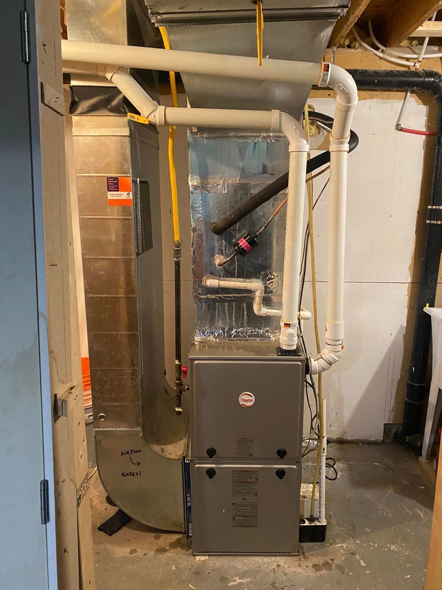 Furnace and ductwork in a basement; gray and white metal components.