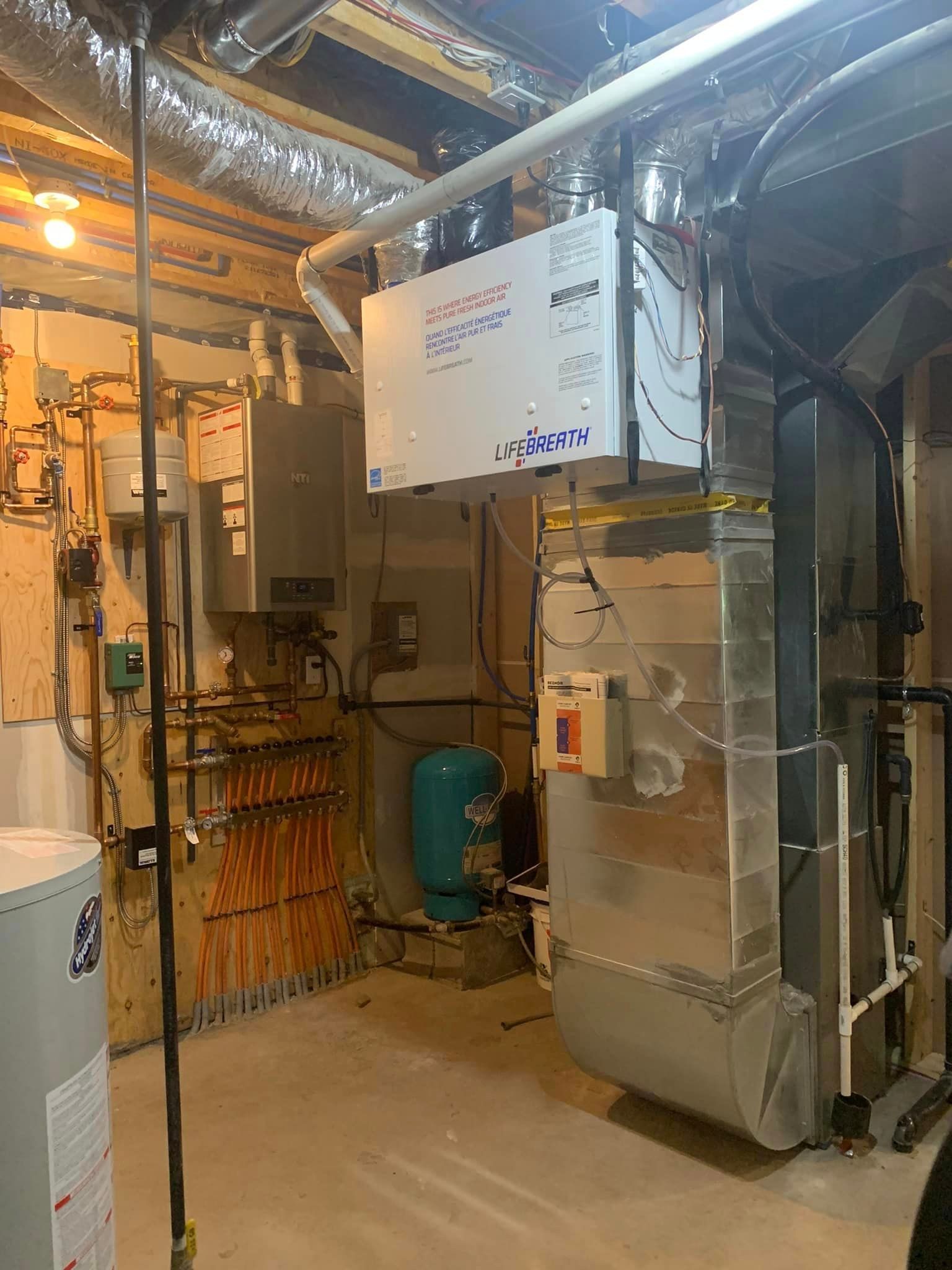 A basement utility room with HVAC equipment, including a humidifier and ductwork, and a water heater.