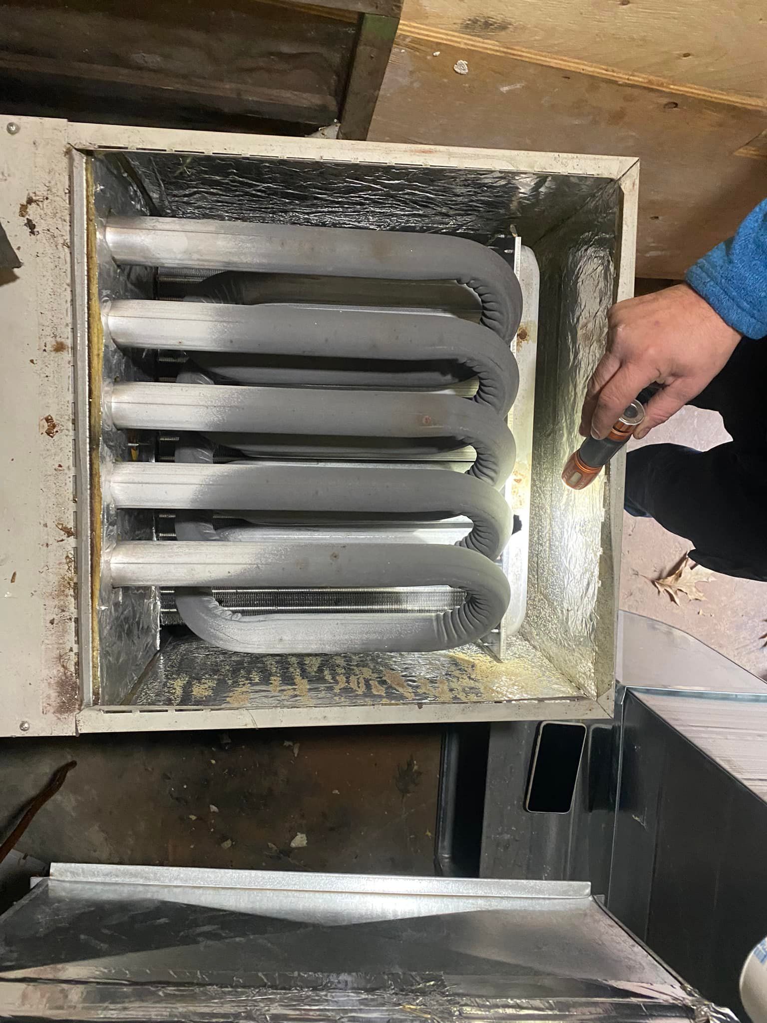 Furnace with frozen coils; a hand points to the frost inside.