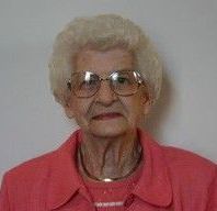 A black and white photo of an elderly woman wearing glasses.