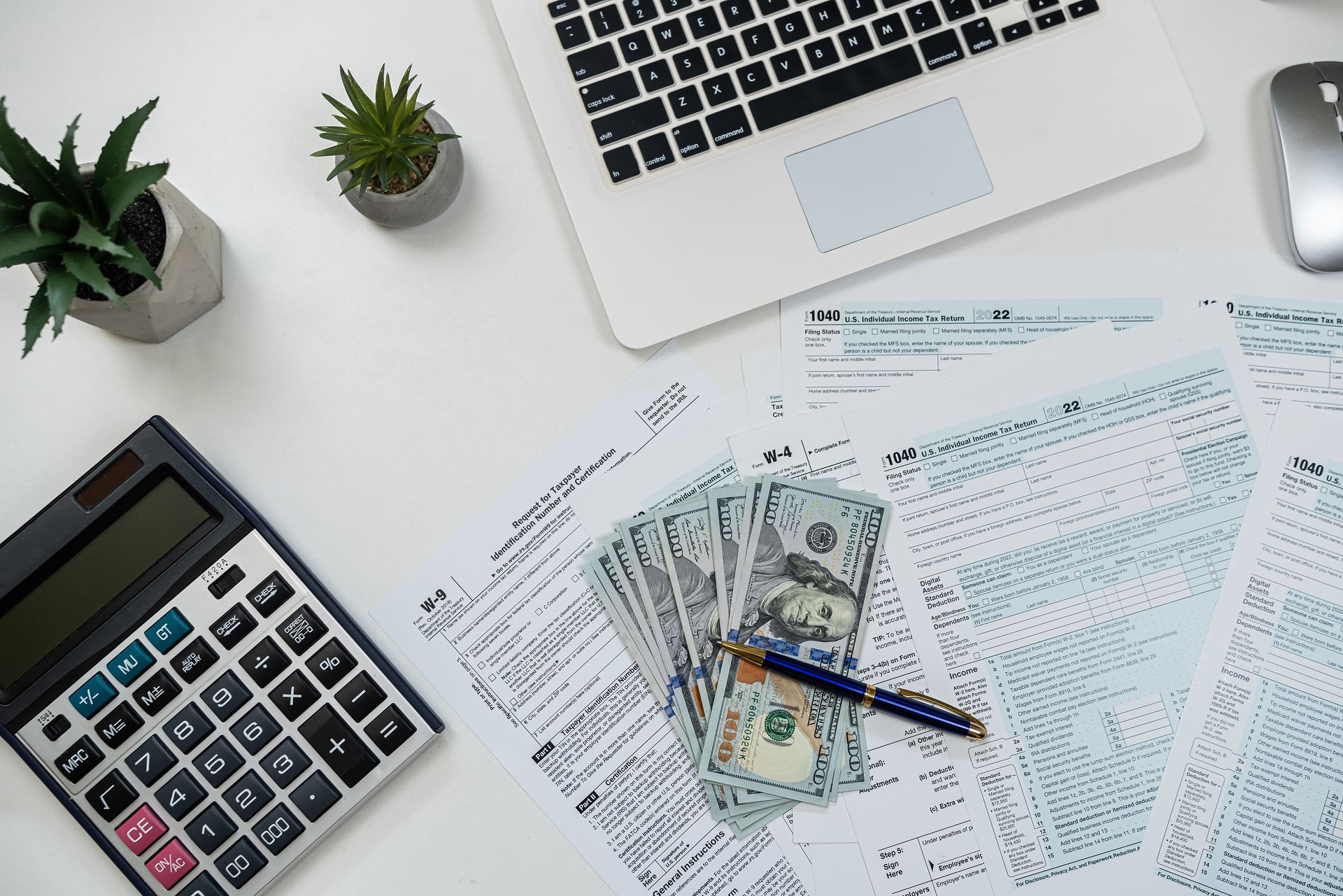 US tax form with dollar and calculator on desk.