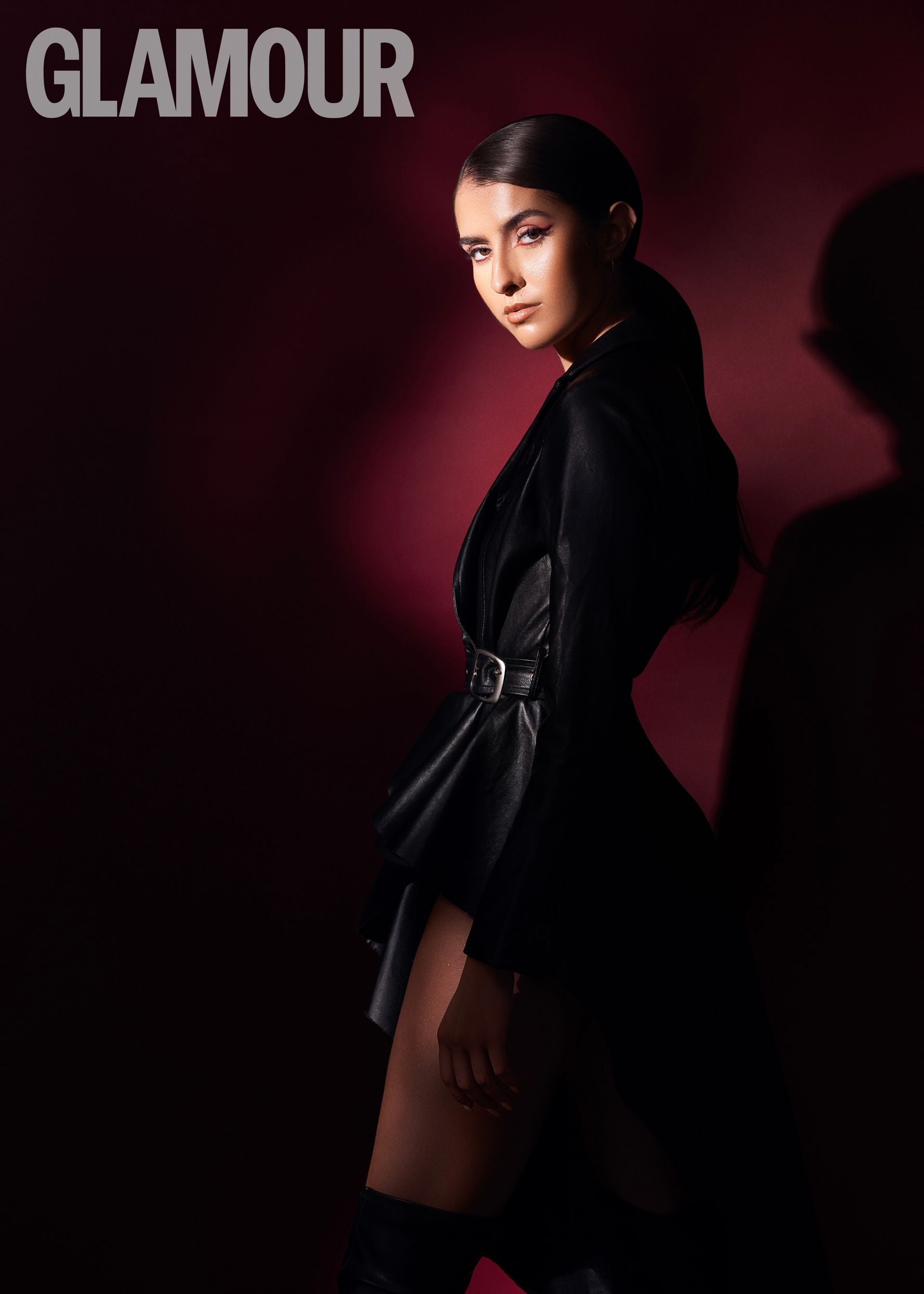 A woman in a black dress is on the cover of glamour magazine