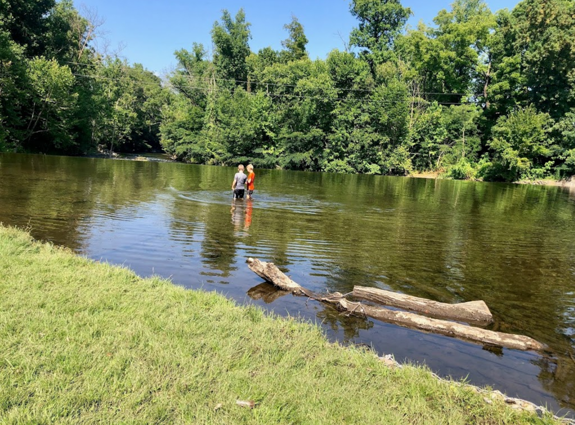 A couple of people are standing in a river.