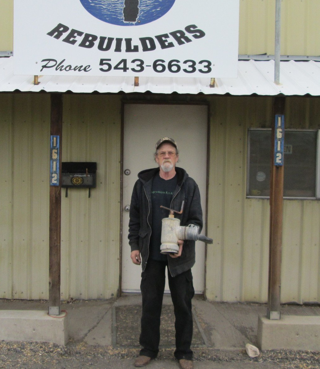 A man standing in front of a building that says rebuilders