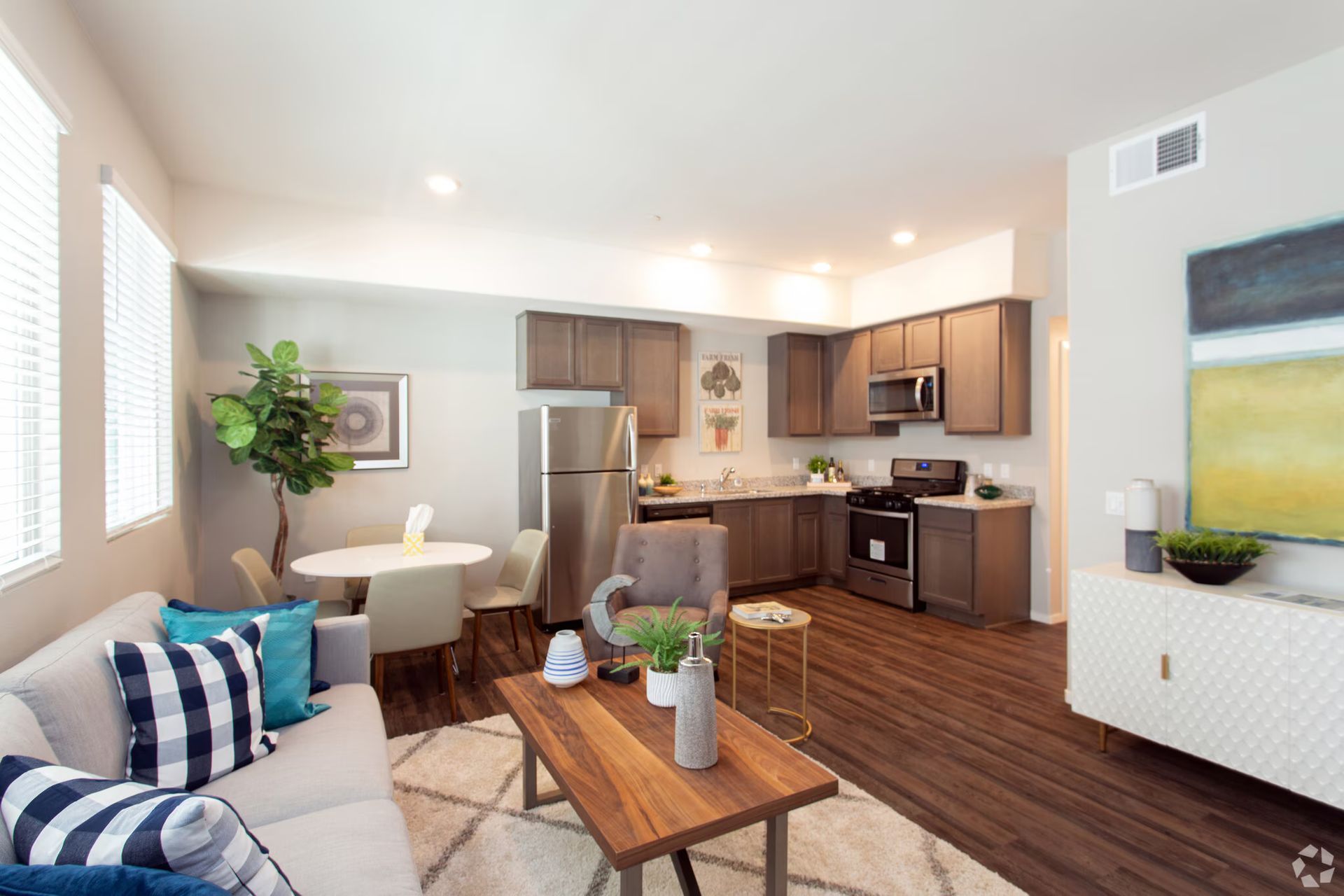 Photo showing a living room with the kitchen in the background