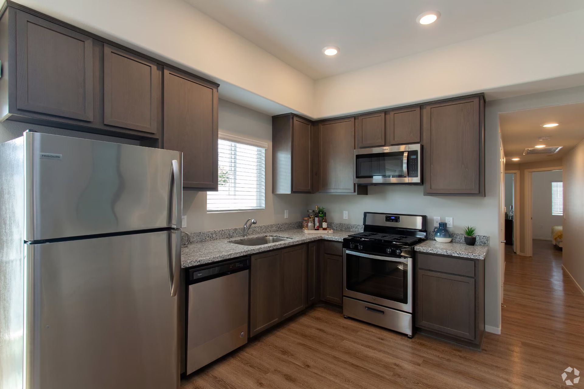 Photo showing an L-shaped kitchen with the hallway in the background