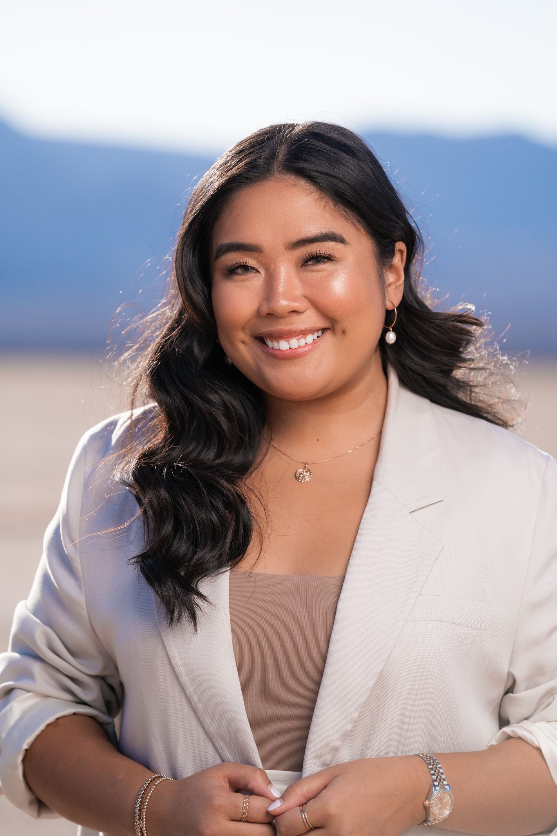 A woman in a white jacket is smiling for the camera.